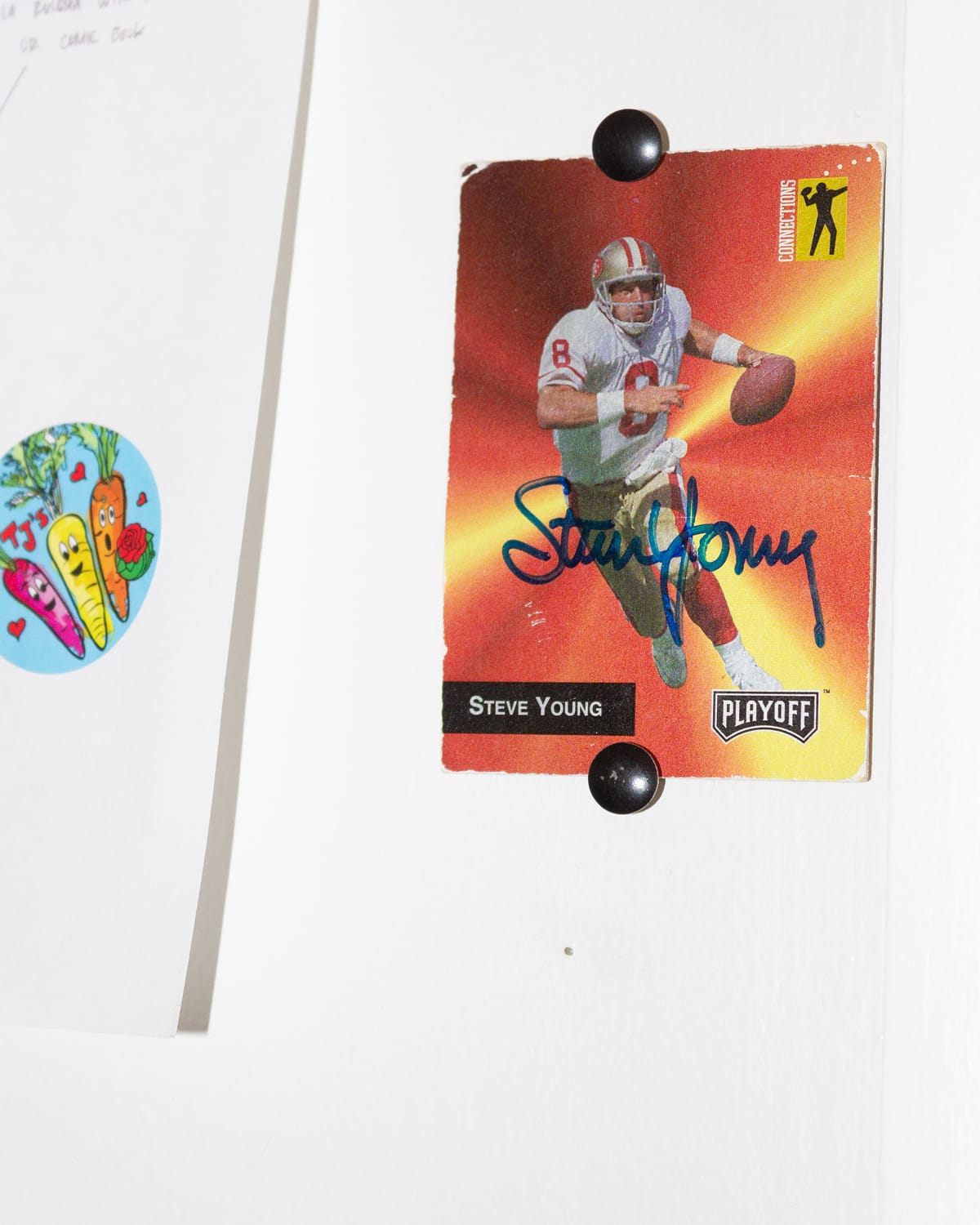 A tape dispenser, scissors, and two clay figurines under a computer monitor on a desk.